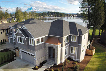 Aerial view of a house on a lake with Mt. Raininer in the background. Taken with a drone.