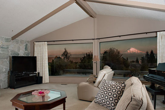 A photo of Mt. Rainier through a living room window at sunset.